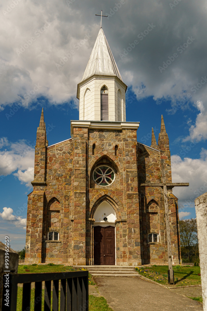 Fototapeta premium The Catholic church. The old red brick church. A historical building with a religious purpose.