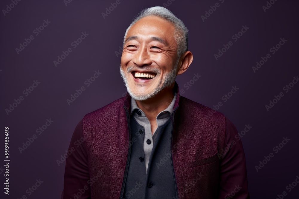 Portrait of a happy asian man in his 60s wearing a chic cardigan isolated in solid color backdrop Portrait of a happy asian man in his 60s wearing a chic cardigan isolated in solid color backdrop