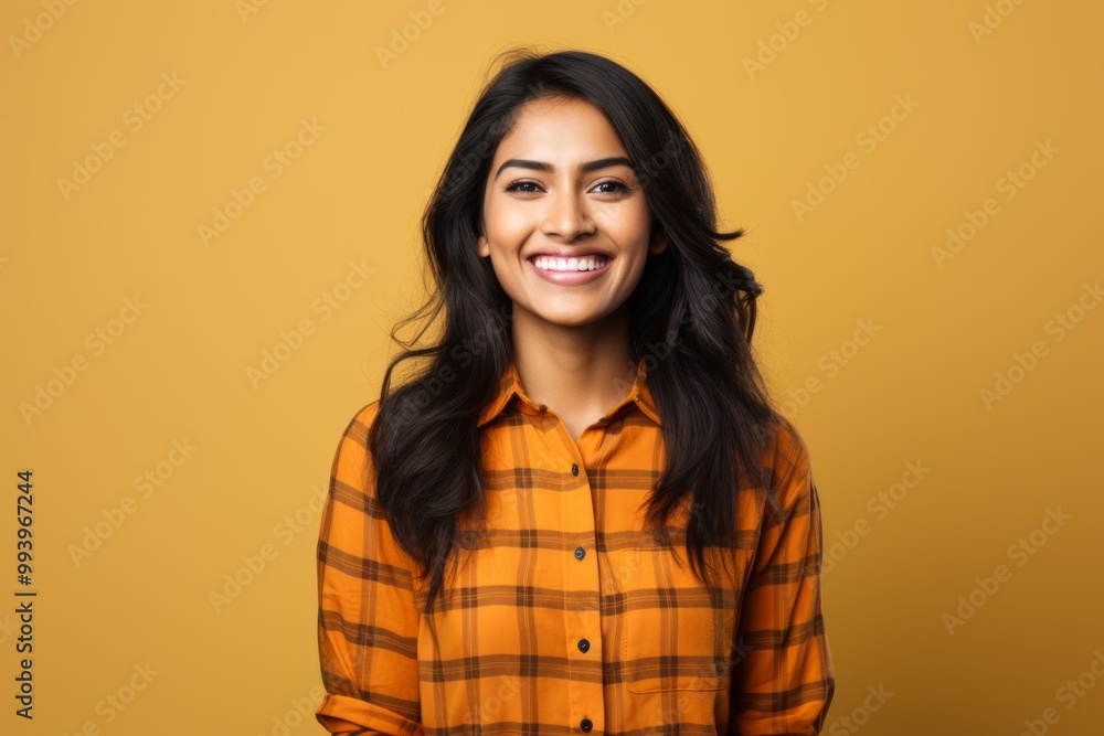 Portrait of a happy indian woman in her 20s dressed in a relaxed flannel shirt in solid color backdrop Portrait of a happy indian woman in her 20s dressed in a relaxed flannel shirt in solid color backdrop