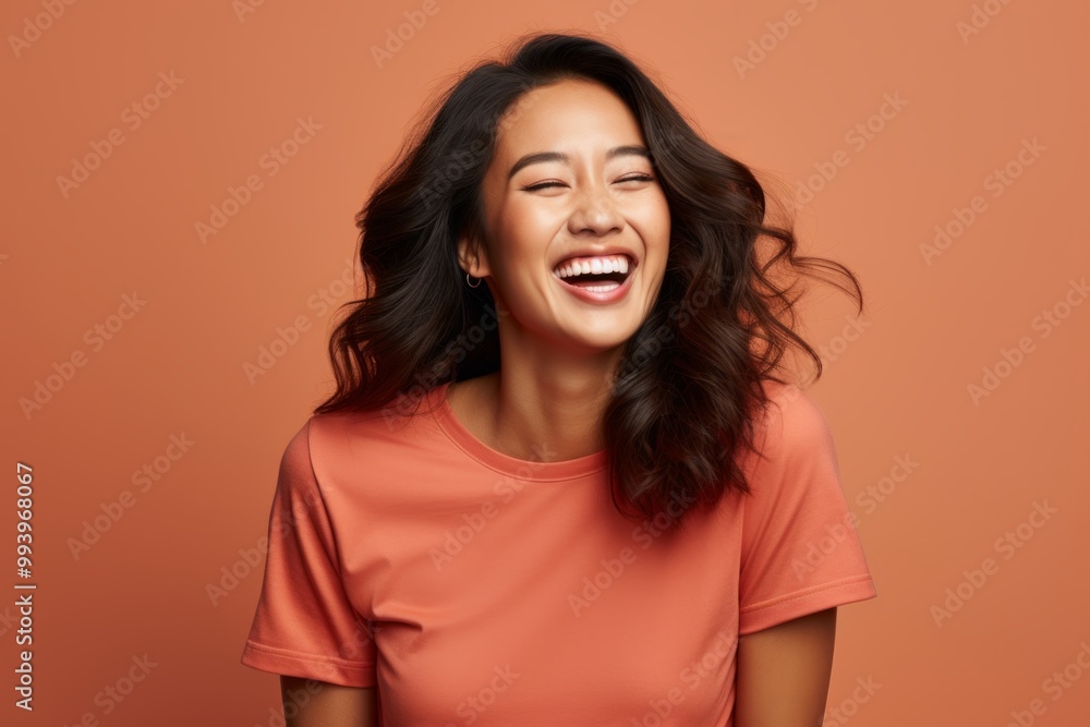 Portrait of a happy asian woman in her 20s showing off a thermal merino wool top isolated in solid color backdrop Portrait of a happy asian woman in her 20s showing off a thermal merino wool top isolated in solid color backdrop