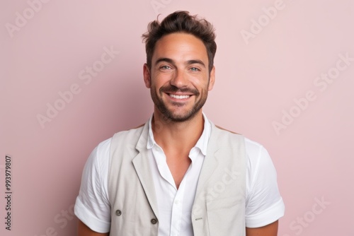 Portrait of a grinning man in his 30s dressed in a breathable mesh vest in solid pastel color wall