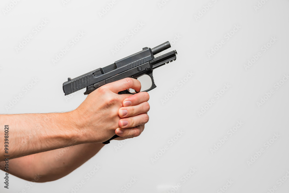Close up of a person demonstrating holding a firearm / pistol with two hands shooting hands on the trigger Close up of a person demonstrating holding a firearm / pistol with two hands shooting hands on the trigger