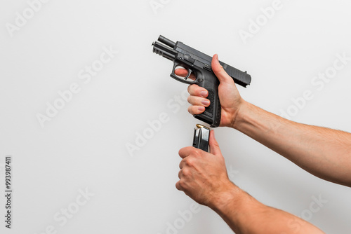 Close up of a man / woman two hands demonstrating reloading with magazine a handgun / pistol / firearm