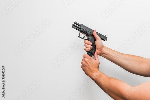 Close up of a man / woman two hands demonstrating reloading with magazine a handgun / pistol / firearm