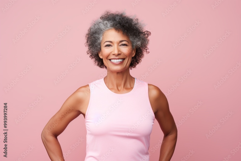 Portrait of a glad afro-american woman in her 60s wearing a lightweight running vest while standing against solid pastel color wall Portrait of a glad afro-american woman in her 60s wearing a lightweight running vest while standing against solid pastel color wall