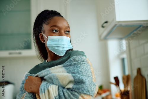 Black woman with protective face mask at home. photo