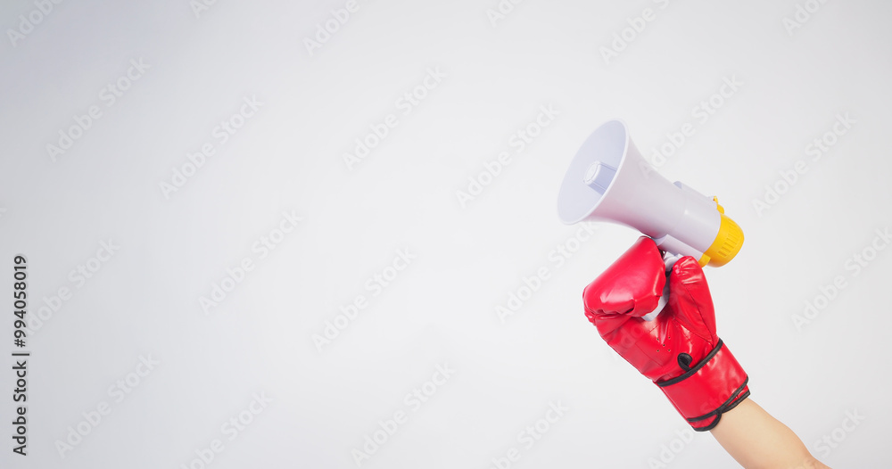 Hand is hold megaphone and wear red boxing gloves on white background. Hand is hold megaphone and wear red boxing gloves on white background.