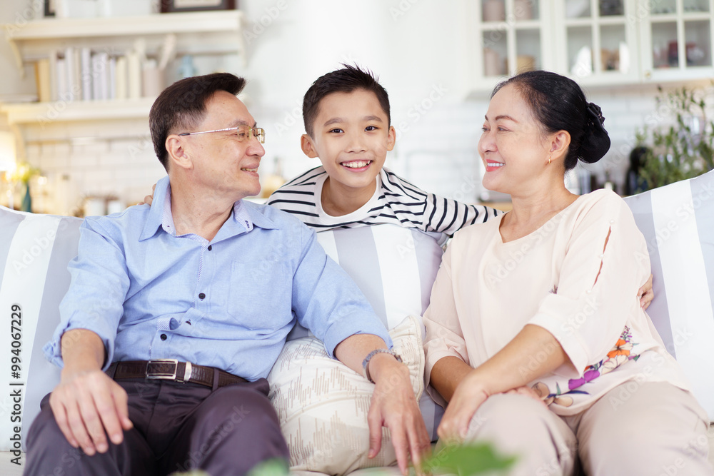 Asian family with father, mother, and son staying in living room together. Asian family with father, mother, and son staying in living room together.