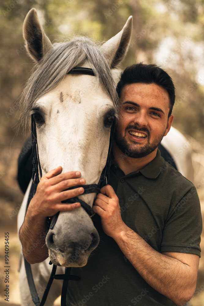 Obraz premium Portrait happy man and his horse's head looking at camera. Concept love for pets. Vertical photo.