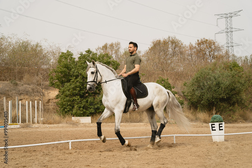 Young rider riding his horse in an arena at an equestrian centre.