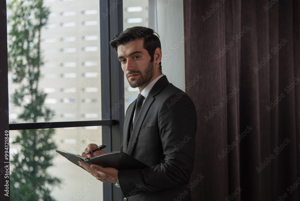 Fototapeta premium Portrait of young handsome confident businessman in suit