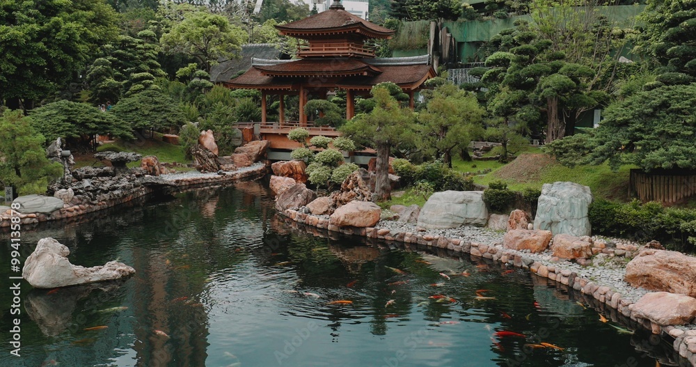Naklejka premium Serene Japanese garden with wooden pavilion, koi pond, lush greenery, and rock formations. Peaceful and tranquil outdoor landscape perfect for relaxation and meditation.