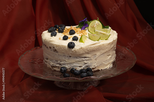 Fresh Bakery Style Carrot Cake displayed on glass cake plate with red draped Fabric on background