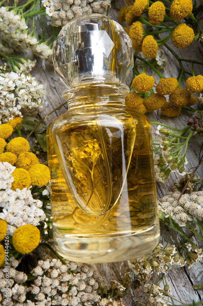 author perfume bottles around yellow flowers at wooden old style background . flat lay. perfumery concept. close up