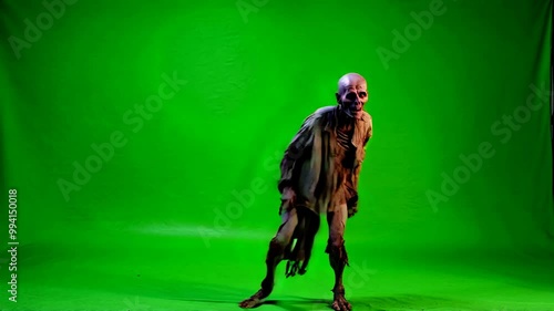 Undead zombie performing dance moves on green screen, horror character for VFX