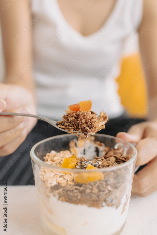Happy asian woman eating healthy homemade snack made of yogurt. Happy asian woman eating healthy homemade snack made of yogurt.