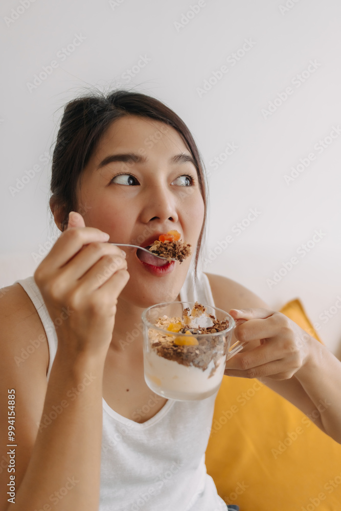 Happy asian woman eating healthy homemade snack made of yogurt. Happy asian woman eating healthy homemade snack made of yogurt.