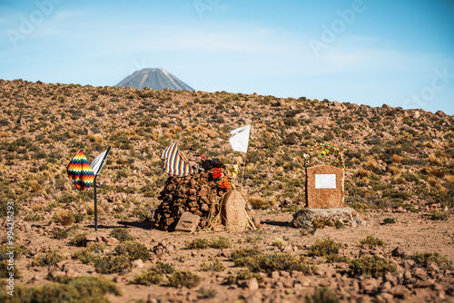 Traditional apacheta (or apachita) stands as a ceremonial offering to Pachamama, surrounded by colorful decorations and artifacts, nestled in Atacama Desert near Machuca, San Pedro de Atacama, Chile. photo