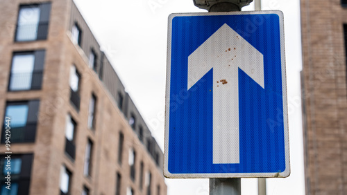 Blue One-Way Traffic Sign with Urban Building Background