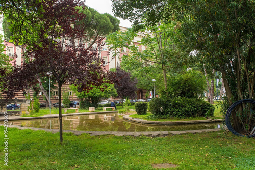 Lulishte Ismail Qemali Park in central Tirana, Albania. Located on the edge of the Blloku area, it's also known as Postblloku Park and is a small green oasis featuring a pond in the middle of this cap
