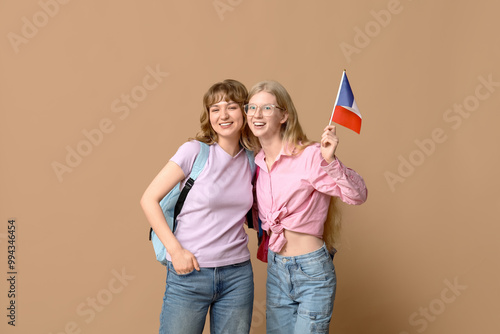 Female students with French flags on beige background