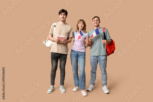 Group of students with French flags on beige background