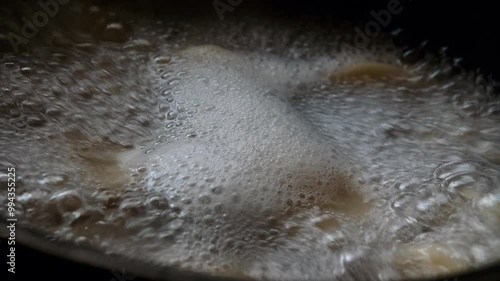 Water boils in a saucepan. Ravioli boiling in water. Boiling water foams. Dumplings are cooked in sauce. Hot water bubbles on the fire in the kitchen. Delicious food is being prepared. Cook food