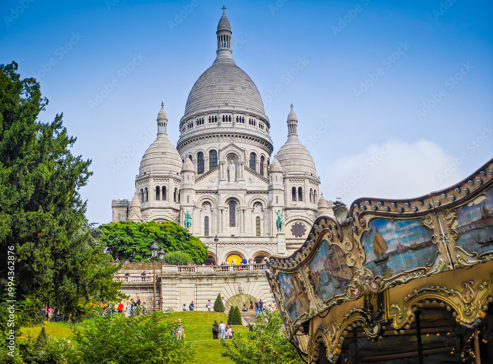 Obraz premium Fragment of colourful carousel with Basilique Du Sacre Coeur de Montmartre. Close up photo of Sacred heart iconic white-domed church in Paris, France