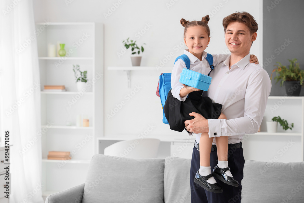 Fototapeta premium Little girl with school lunchbox and her father at home