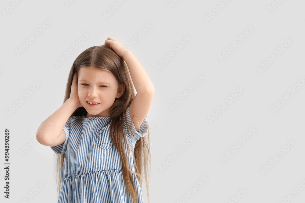 Little girl with pediculosis scratching her head on light background Little girl with pediculosis scratching her head on light background