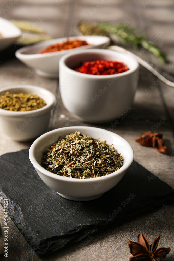 Bowls of different aromatic spices on grunge tile table Bowls of different aromatic spices on grunge tile table