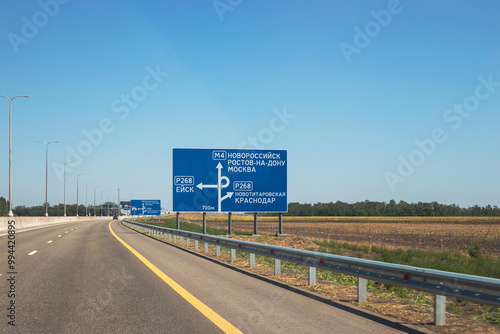 Road with road information sign. On the blue plate are the inscriptions of the cities Novorossiysk, Rostov-on-Don, Moscow photo