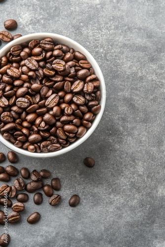 Freshly roasted coffee beans in a white bowl on a gray countertop, perfect fo...