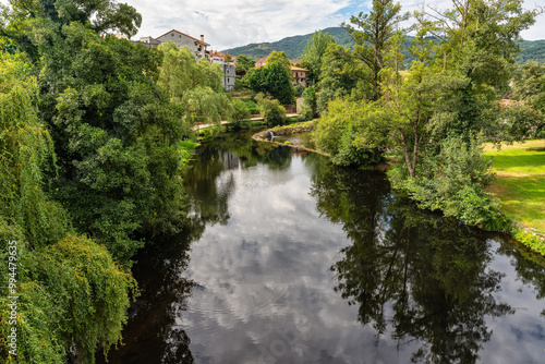 Lush landscape with willow trees and green vegetation with the Arnoia River in the village of Allariz, Orense.