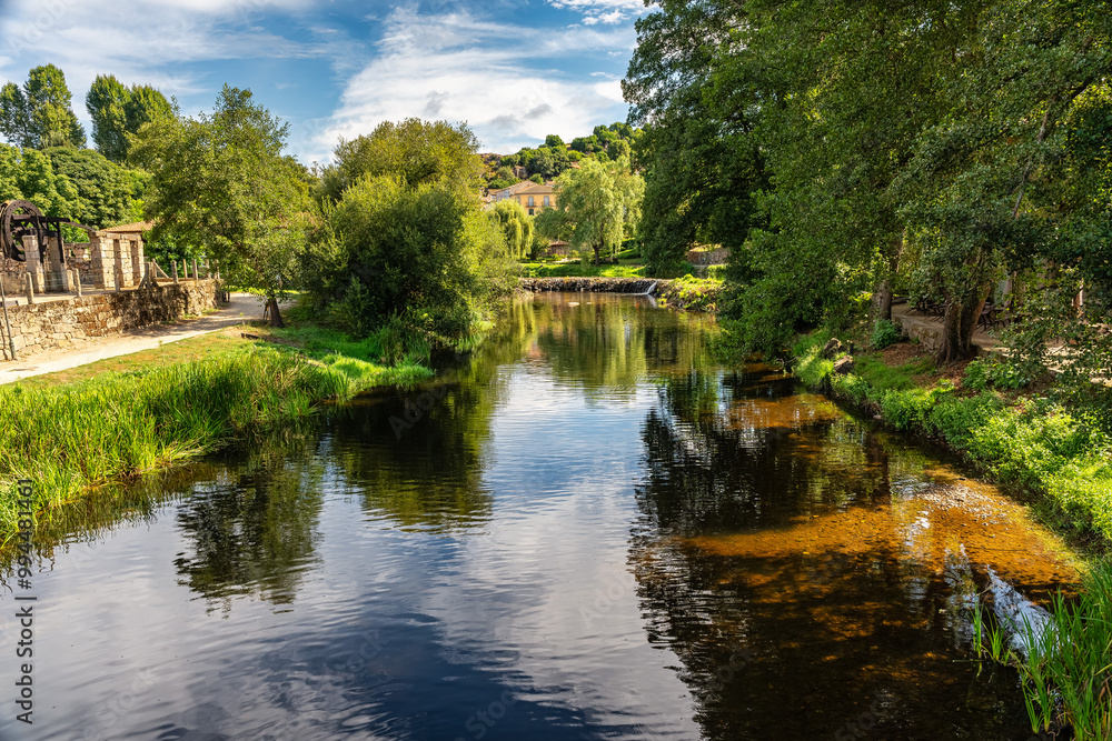 Lush landscape with willow trees and green vegetation with the Arnoia River in the village of Allariz, Orense. Lush landscape with willow trees and green vegetation with the Arnoia River in the village of Allariz, Orense.