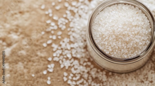 Freshly poured salt in a glass bowl on a rustic wooden table at home in natur...