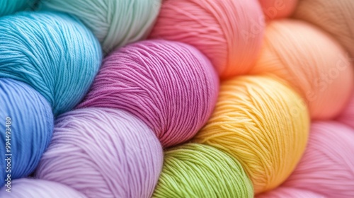 Colorful skeins of yarn stacked together in vibrant shades for crafting proje...