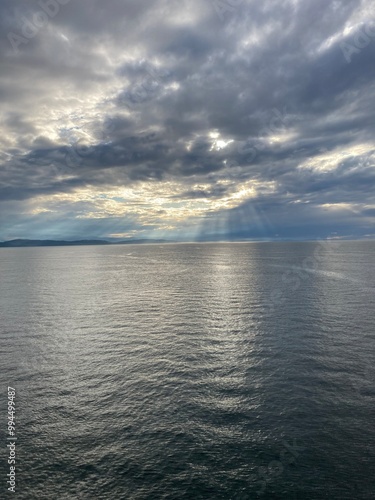 Sun rays through the clouds over a calm sea