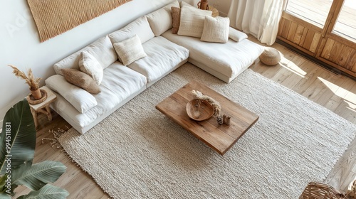 Airy Scandinavian living room featuring a low-profile sectional sofa, a large wool area rug, and a minimalist wood coffee table photo