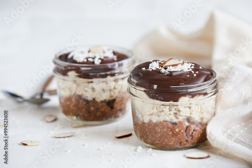 Fotografía Two jars of homemade chocolate overnight oatmeal with shredded coconut and sliced almonds