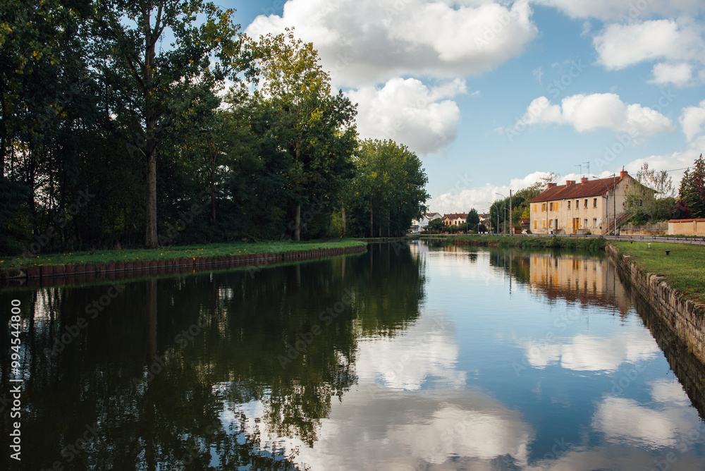 Canal du centre à Ecuisses. Reflet des nuages et d'une maison dans une rivière. Des nuages, un ciel bleu et une maison se reflètent dans une rivière. Canal du centre à Ecuisses. Reflet des nuages et d'une maison dans une rivière. Des nuages, un ciel bleu et une maison se reflètent dans une rivière.