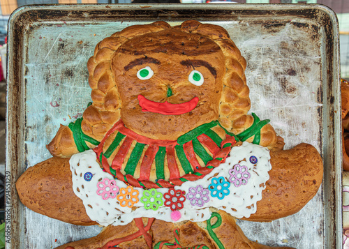 Large 'Guagua de pan' bread decorated as a chola cuencana in traditional costume from the province of Azuay, on a tray. Traditional Ecuadorian food for the 'Day of the Dead'. Cuenca, Ecuador