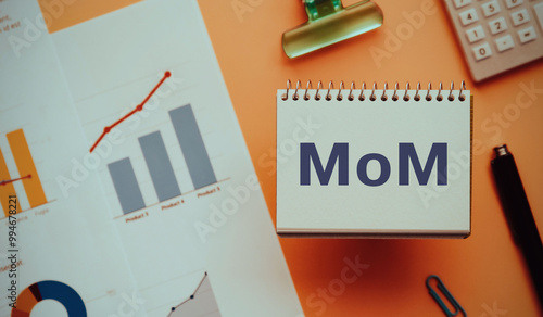 There is notebook with the word MoM. It is an abbreviation for month over month as eye-catching image.