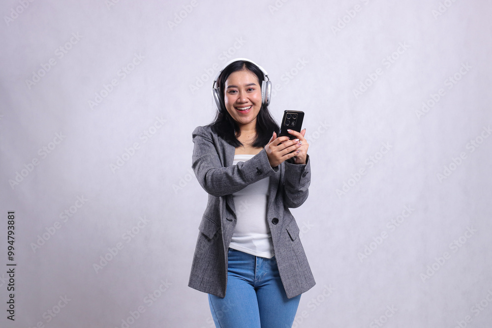 Beautiful office lady asia cheerful wearing headphone headset and holding mobile phone streaming video wearing suit isolated on white background. lifestyle, education, entertainment, technology Beautiful office lady asia cheerful wearing headphone headset and holding mobile phone streaming video wearing suit isolated on white background. lifestyle, education, entertainment, technology