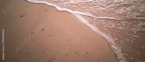 Foamy waves across the wet sandy beach