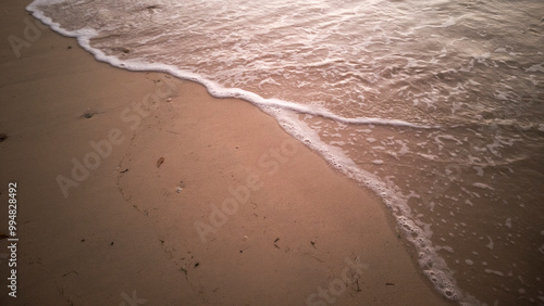 Close up foamy white pattern waves coming to sand beach