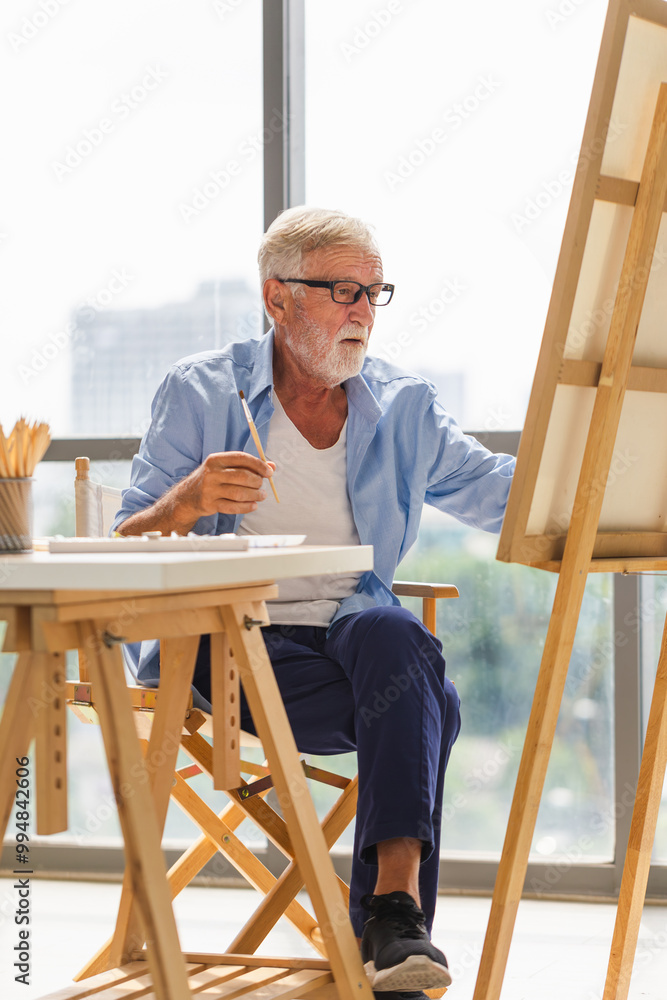 Senior man painting on canvas at home, Elderly man painting on a canvas, Happy retirement concepts Senior man painting on canvas at home, Elderly man painting on a canvas, Happy retirement concepts