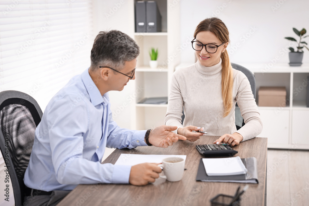 Banker working with client at table in office