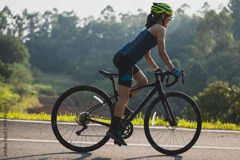 Fitness woman cyclist riding bike in summer park Fitness woman cyclist riding bike in summer park