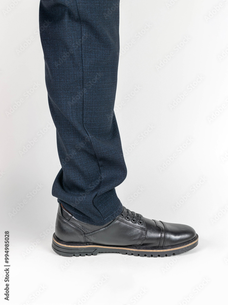 Close-Up of Man's Leg in Blue Trousers and Black Formal Shoe Isolated on White Background